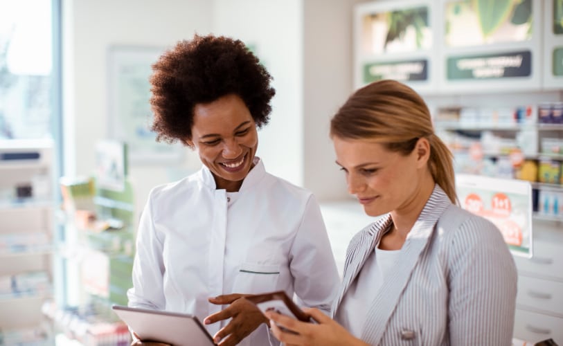 Pharmacists reviewing medication information together on a tablet