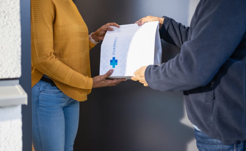 A customer receiving a pharmacy package at their front door