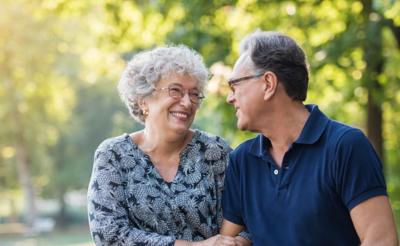 An older couple smiling together outdoors