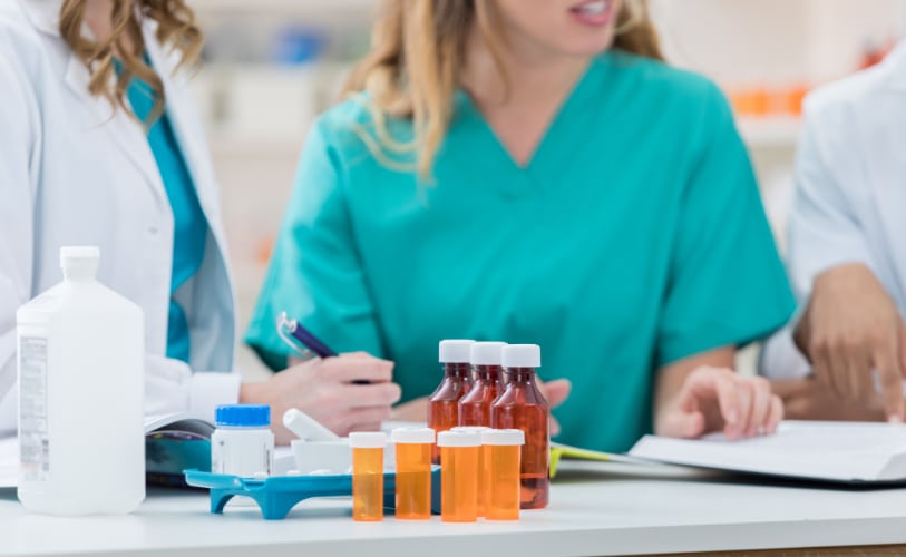 Pharmacy staff reviewing medications and notes together